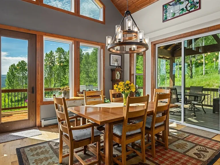 Dining room with wood beams and mountain views
