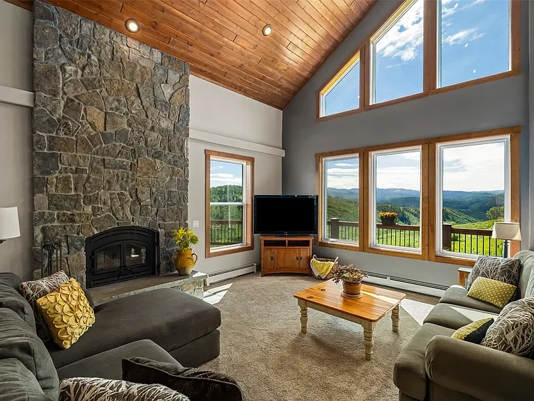Luxury mountain home living room with stone fireplace and panoramic views